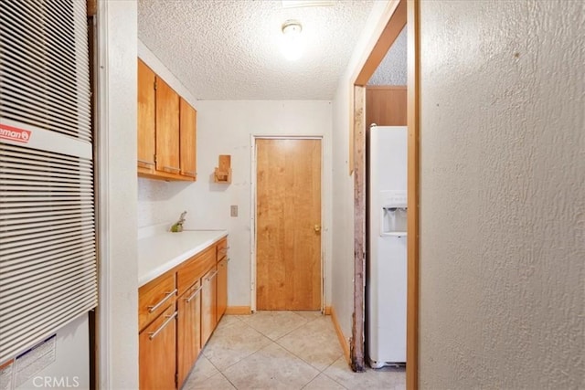 interior space with white refrigerator with ice dispenser, a heating unit, brown cabinets, light countertops, and light tile patterned flooring