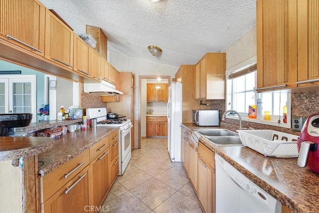 kitchen with tasteful backsplash, dark countertops, a sink, white appliances, and under cabinet range hood