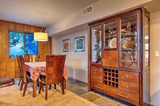 dining space featuring wood walls