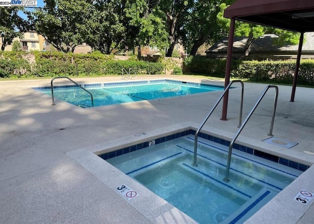 view of pool with a hot tub