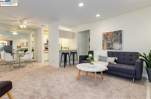 living room with ceiling fan and light colored carpet