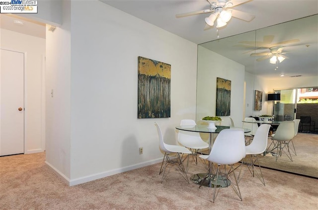 carpeted dining room with ceiling fan