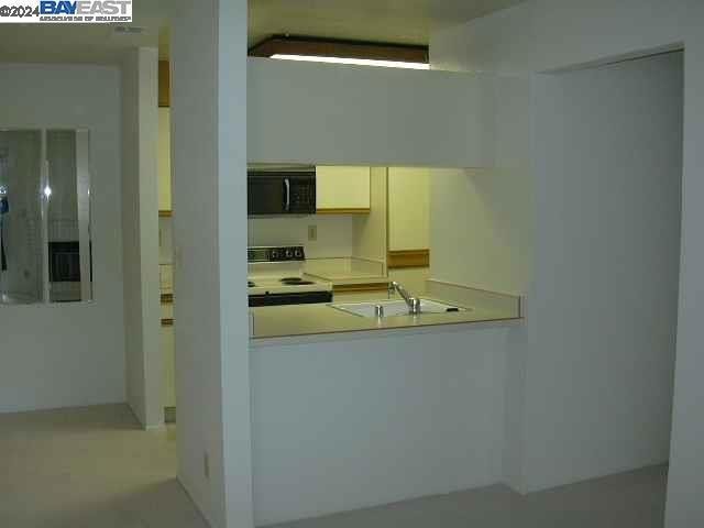 kitchen featuring white range with electric cooktop and sink