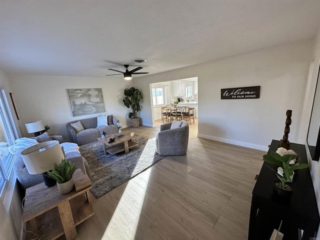 living room featuring ceiling fan and light hardwood / wood-style floors