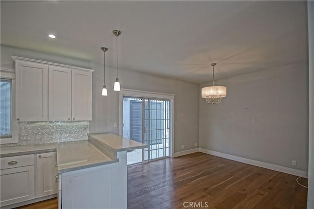 kitchen featuring dark hardwood / wood-style floors, white cabinetry, and hanging light fixtures