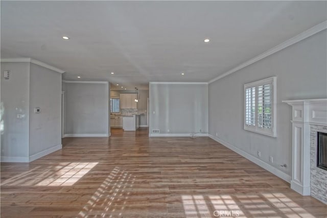 unfurnished living room featuring crown molding and light wood-type flooring