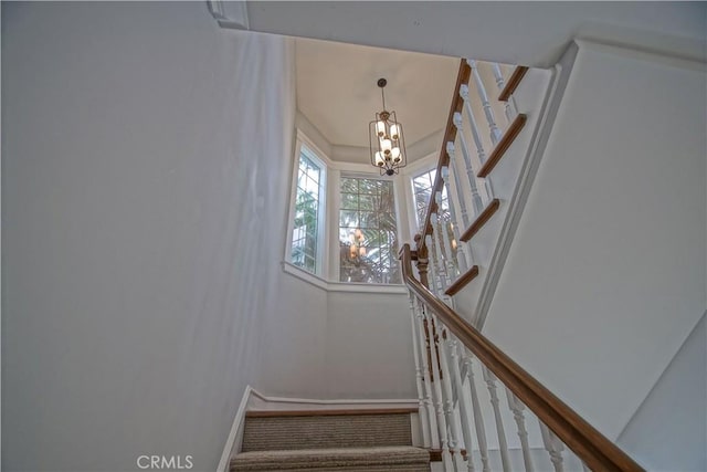 stairs featuring an inviting chandelier