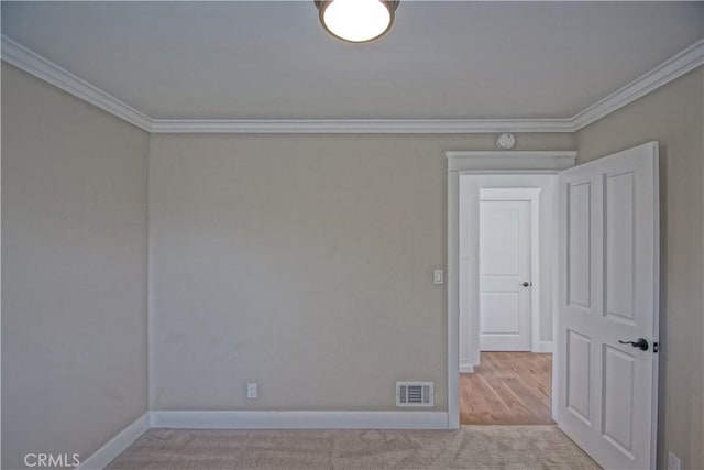 unfurnished room featuring ornamental molding and light carpet