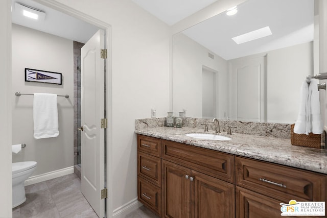 bathroom with vanity, a skylight, an enclosed shower, and toilet