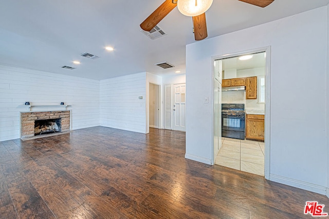 unfurnished living room with ceiling fan, light hardwood / wood-style flooring, and a fireplace