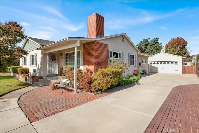 view of front of house featuring a garage and an outbuilding