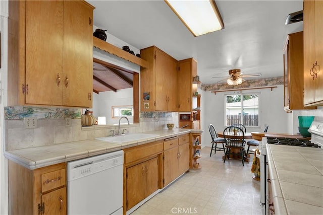 kitchen featuring tile countertops, ceiling fan, backsplash, white appliances, and sink