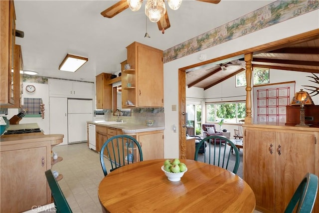 dining space with vaulted ceiling with beams and sink