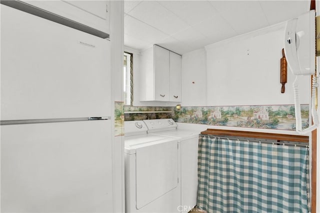 clothes washing area featuring cabinets and washing machine and dryer