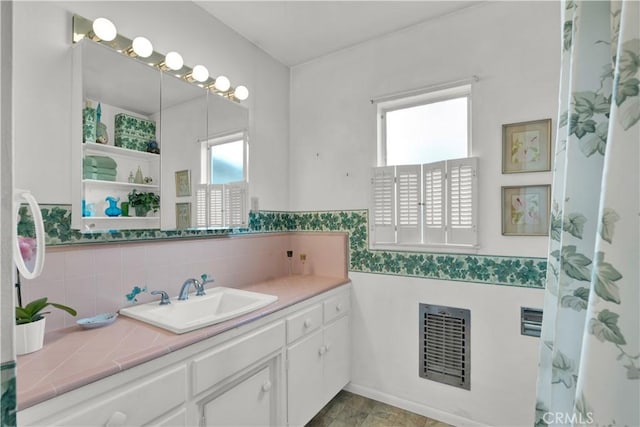 bathroom featuring heating unit and vanity