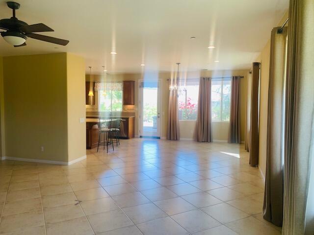 tiled spare room with plenty of natural light and ceiling fan