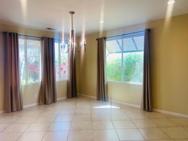 interior space featuring a notable chandelier, light tile patterned floors, and a wealth of natural light