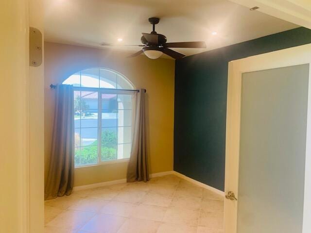 unfurnished room featuring ceiling fan and a healthy amount of sunlight