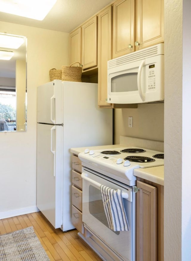 kitchen featuring white appliances and light hardwood / wood-style flooring