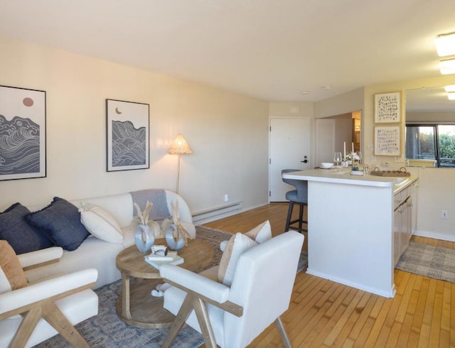 living room with sink, light hardwood / wood-style floors, and a baseboard radiator