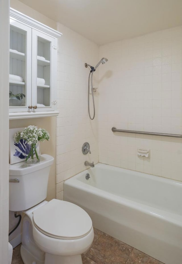 bathroom with toilet and tiled shower / bath combo