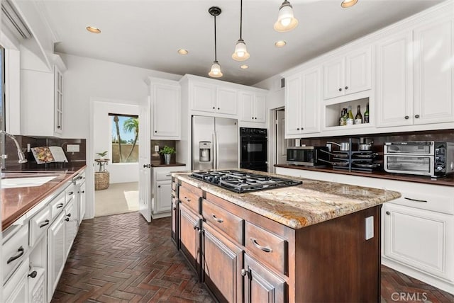 kitchen with white cabinetry, a center island, and black appliances