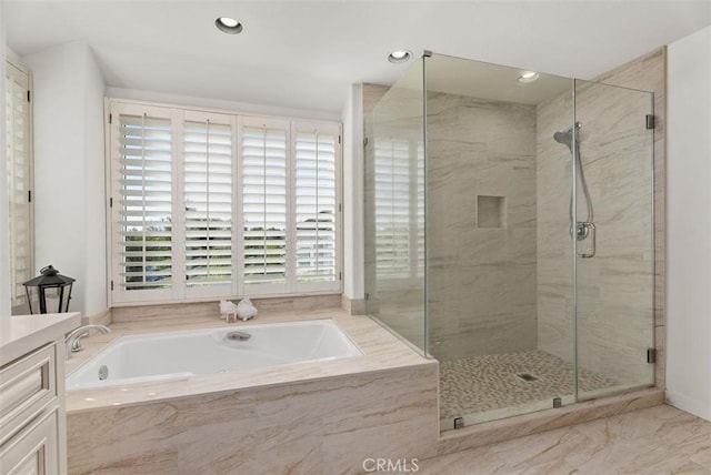 bathroom featuring vanity and independent shower and bath