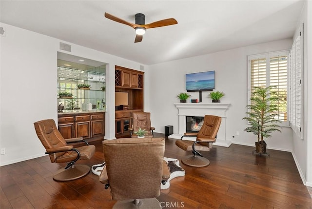 living area featuring dark wood-type flooring and ceiling fan