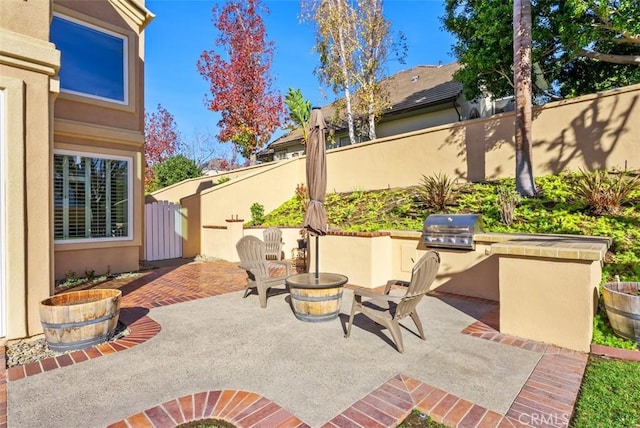 view of patio with area for grilling and an outdoor fire pit