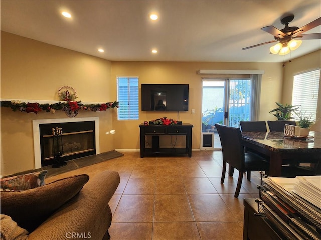 living room with tile patterned floors, a tile fireplace, and ceiling fan