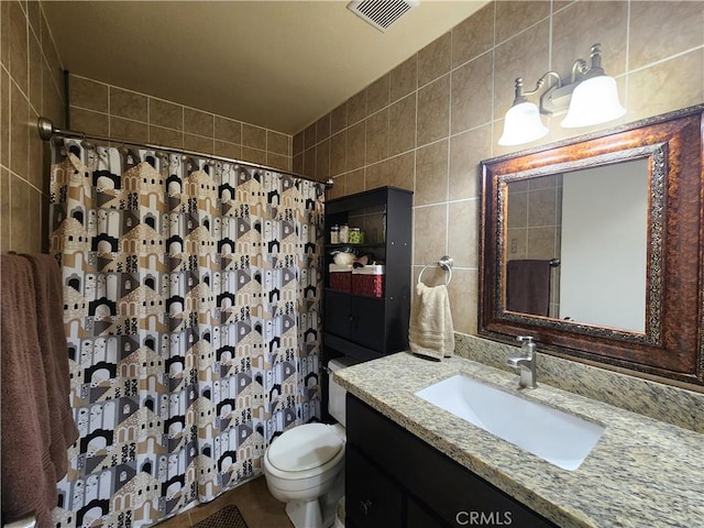 bathroom featuring a shower with shower curtain, vanity, toilet, and tile walls