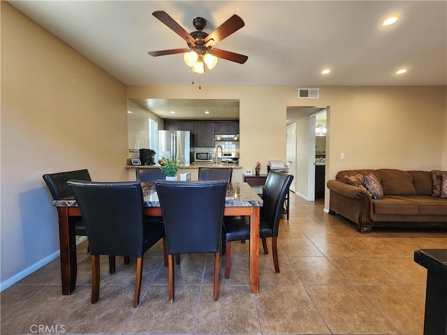 tiled dining space featuring ceiling fan