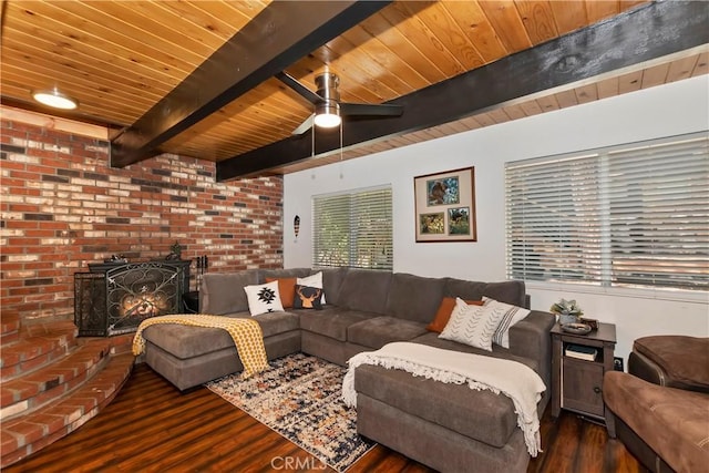 living room featuring dark hardwood / wood-style flooring, a brick fireplace, wood ceiling, ceiling fan, and beamed ceiling