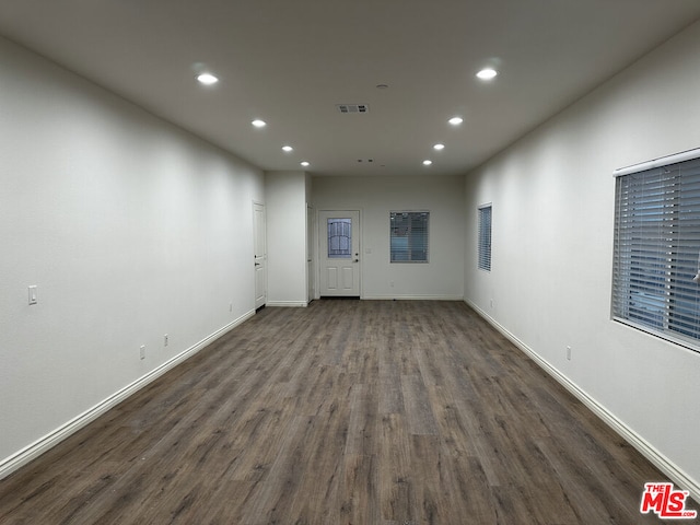 unfurnished room with dark wood-type flooring