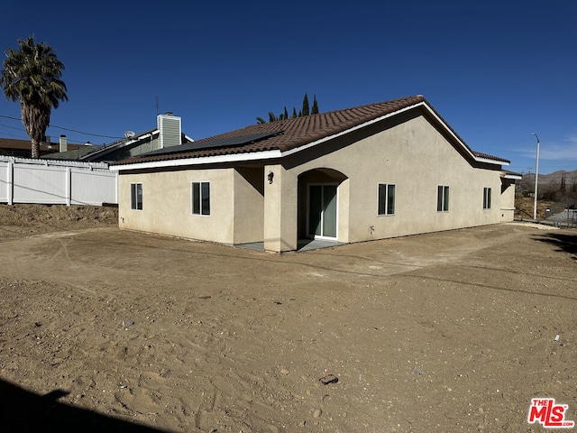 rear view of house featuring solar panels