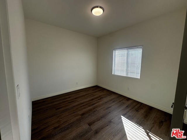 spare room with dark hardwood / wood-style floors