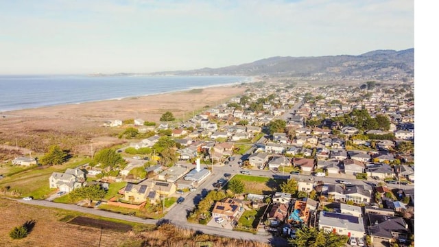 drone / aerial view with a water view and a beach view