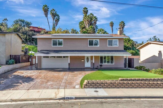 front of property with covered porch, solar panels, and a garage