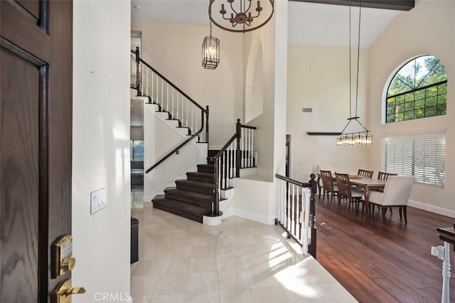 entrance foyer with beamed ceiling, high vaulted ceiling, and light hardwood / wood-style flooring