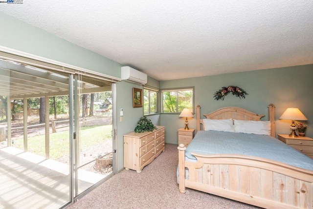 carpeted bedroom featuring a wall unit AC, a textured ceiling, and access to outside