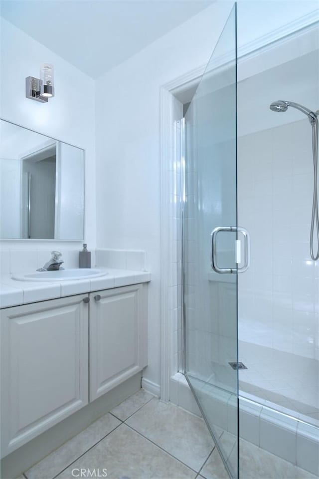 bathroom with tile patterned floors, vanity, and walk in shower