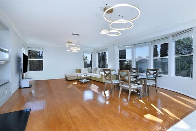 dining area featuring crown molding, plenty of natural light, and light hardwood / wood-style floors