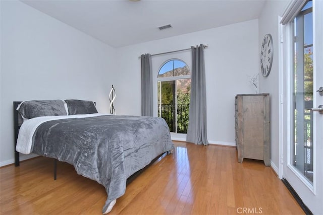 bedroom featuring access to exterior and hardwood / wood-style floors