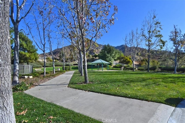 surrounding community featuring a gazebo, a mountain view, and a lawn