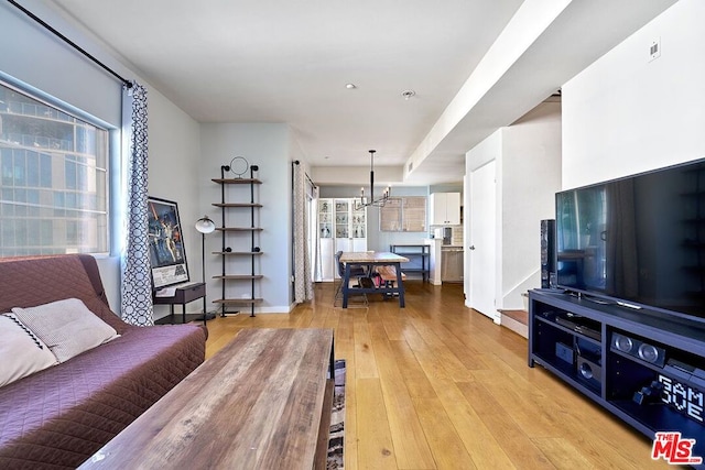 living room featuring a chandelier and light wood-type flooring