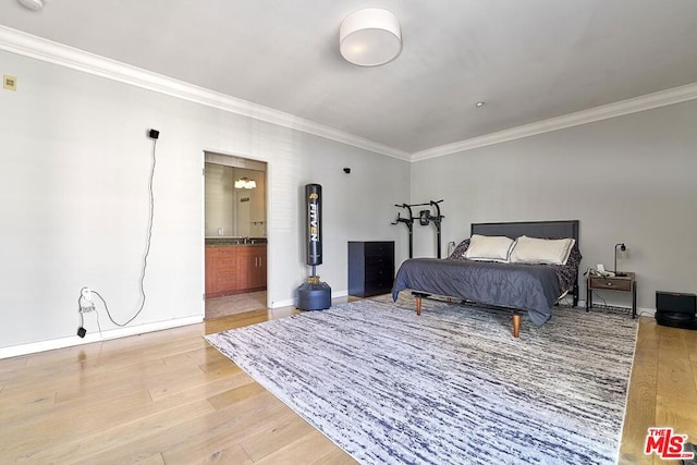 bedroom with wood-type flooring, crown molding, and connected bathroom