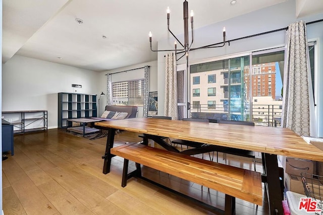 dining space featuring light hardwood / wood-style flooring and a chandelier