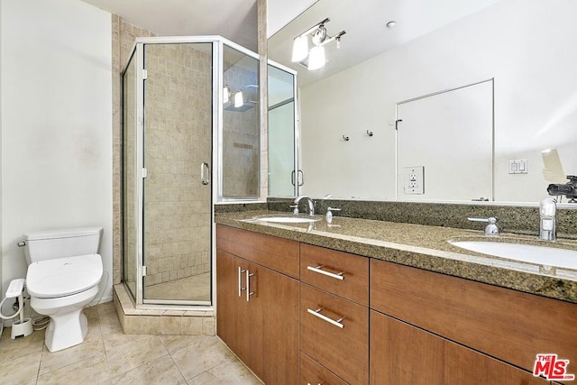 bathroom with tile patterned floors, vanity, toilet, and a shower with shower door