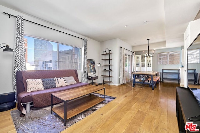 living room with hardwood / wood-style floors and a notable chandelier