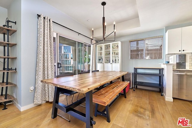 dining area with an inviting chandelier and light hardwood / wood-style flooring